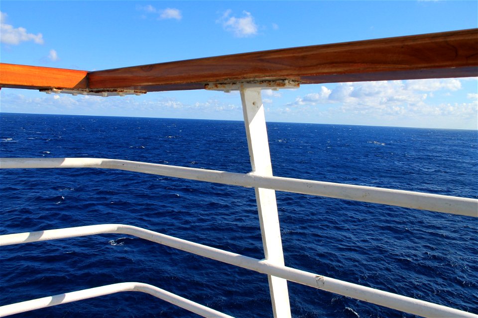 White & Wood Railing Against Ocean photo