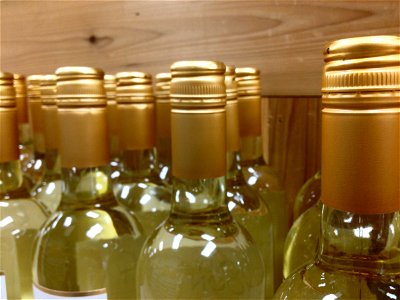 Gold Bottles of Wine Against Wooden Board