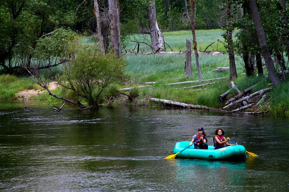 2 Women Paddling in a Raft Down a River photo