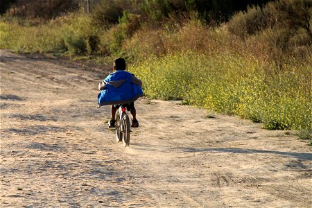 Boy Riding Bike Down Dirt Path photo