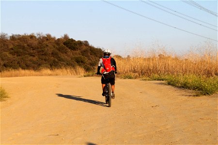 Cyclist Riding Bicycle on Dirt Path photo