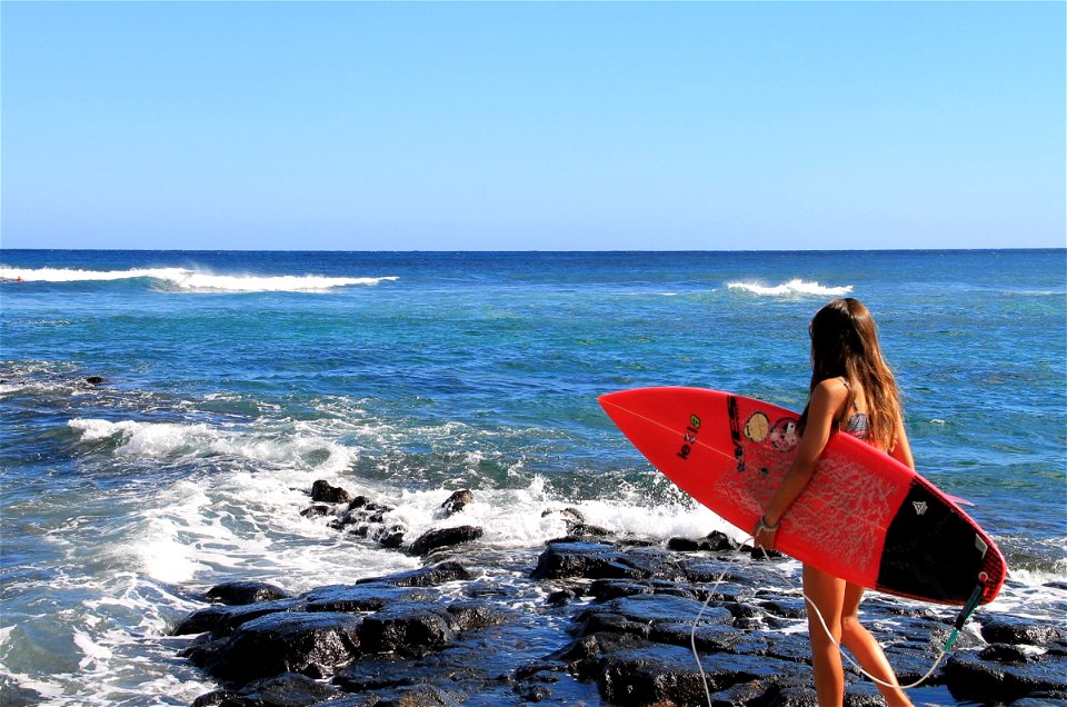 Young Girl Holding Surfboard at Ocean photo