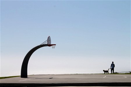 Curved Basketball Hoop & Man With Dog photo