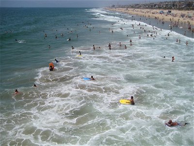 People Wading into Ocean at Beach photo