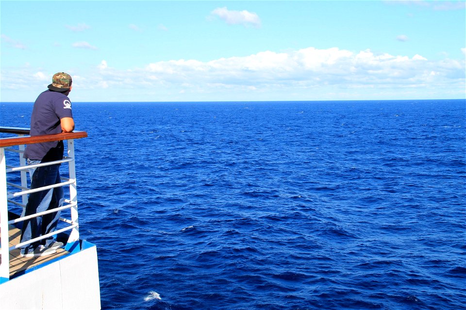 Man on Deck of Cruise Ship Looking at Ocean photo