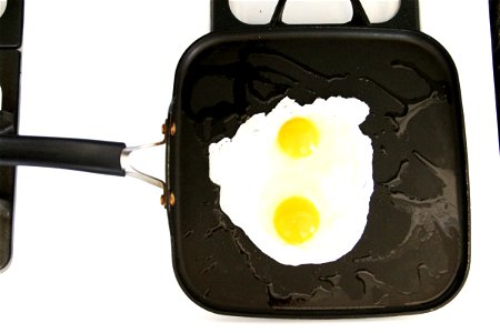 2 Sunny Side Up Eggs Cooking on Skillet photo