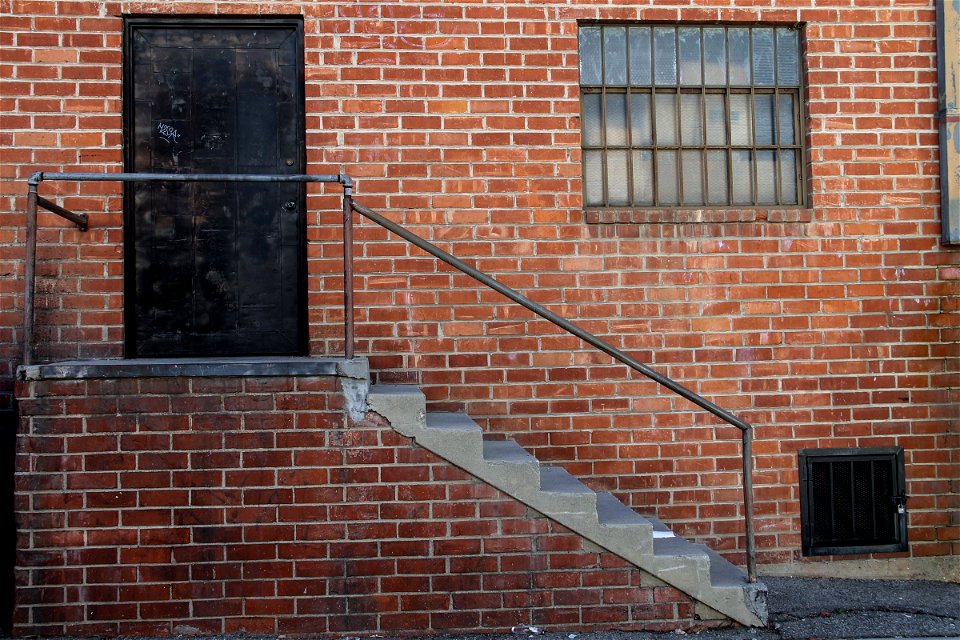 Black Door & Staircase on Brick Building photo