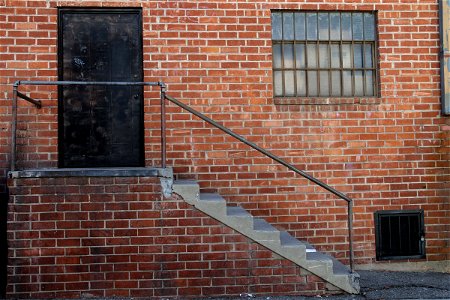 Black Door & Staircase on Brick Building photo