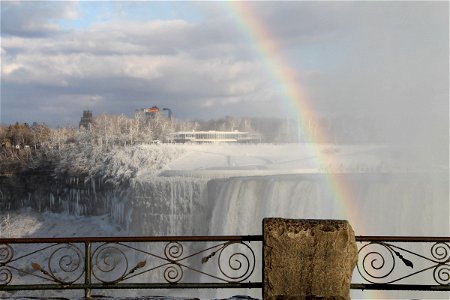Railing in Front of Rainbow Over Frozen Niagara Falls photo