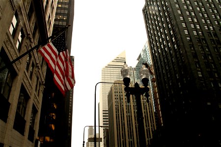 American Flag & Lamp Post Among City Buildings photo