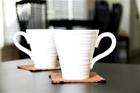 2 White Coffee Mugs on Coasters photo
