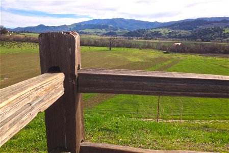 Wood Fence Post with Green Fields photo