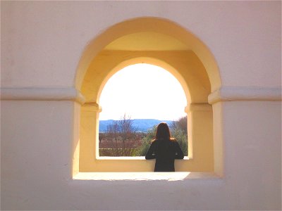 Woman Looking Out Arch Window photo