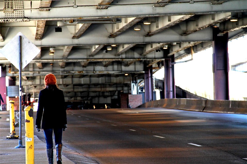 Girl Walking Down Sidewalk of Covered Street