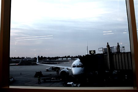 Airplane Docked at Airport Terminal through Glass Window photo