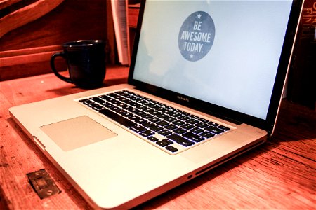 Macbook Laptop with “Be Awesome” Screen with Coffee Mug photo