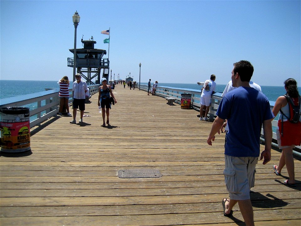 People Walking Along Ocean Pier photo