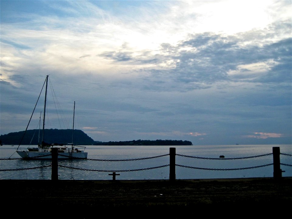 Boat on Still Ocean by Pier