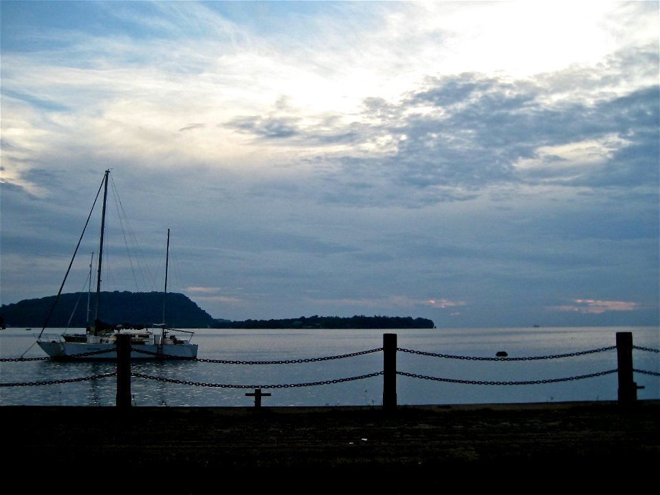 Boat on Still Ocean by Pier photo