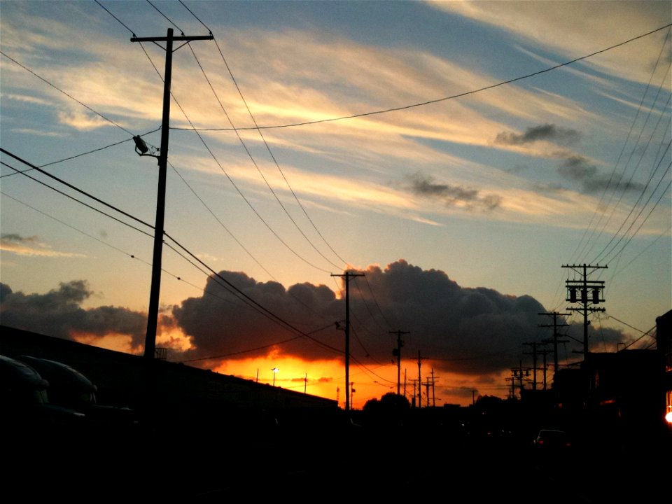 Silhouette of Telephone Poles Against Cloudy Sunset