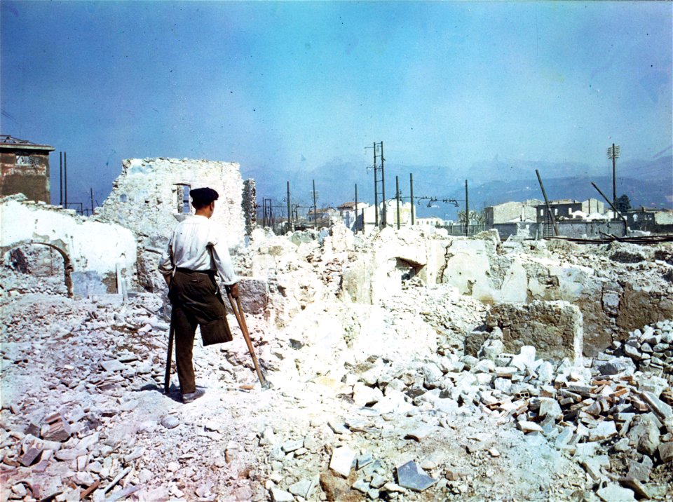 C-914 - An Italian who lost his leg in the bombing of the railroad station at Viareggio a year ago looks at the mass of destruction in the town. 1945. photo