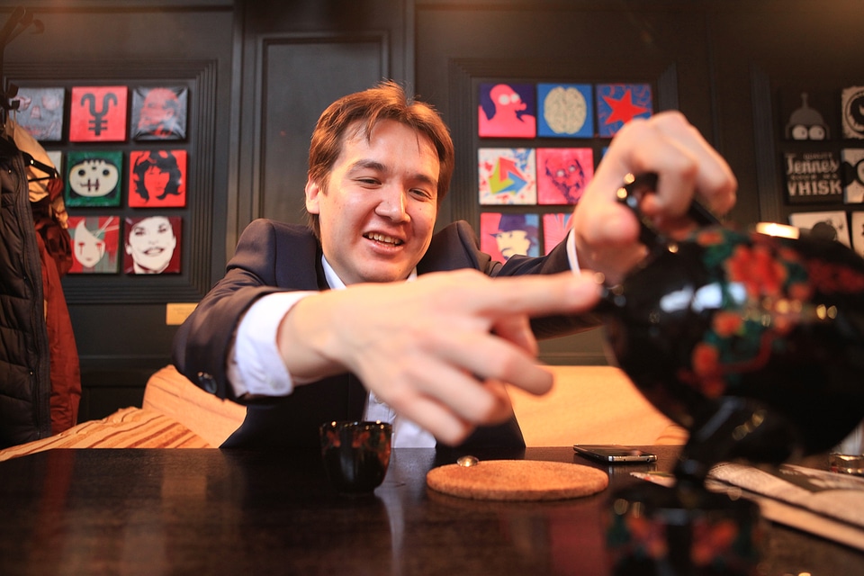 young man pours tea