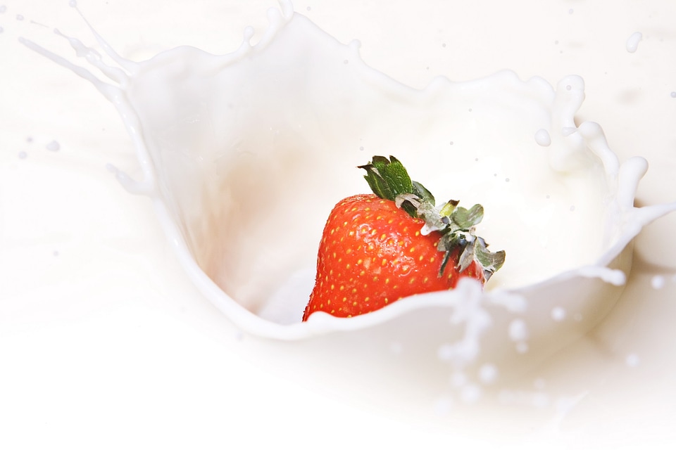 Strawberry dropped in milk