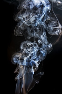 Swirl of blue smoke on black photo