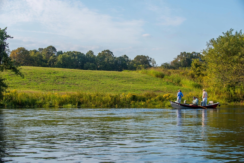 Group fly fishing from drift boat on White River