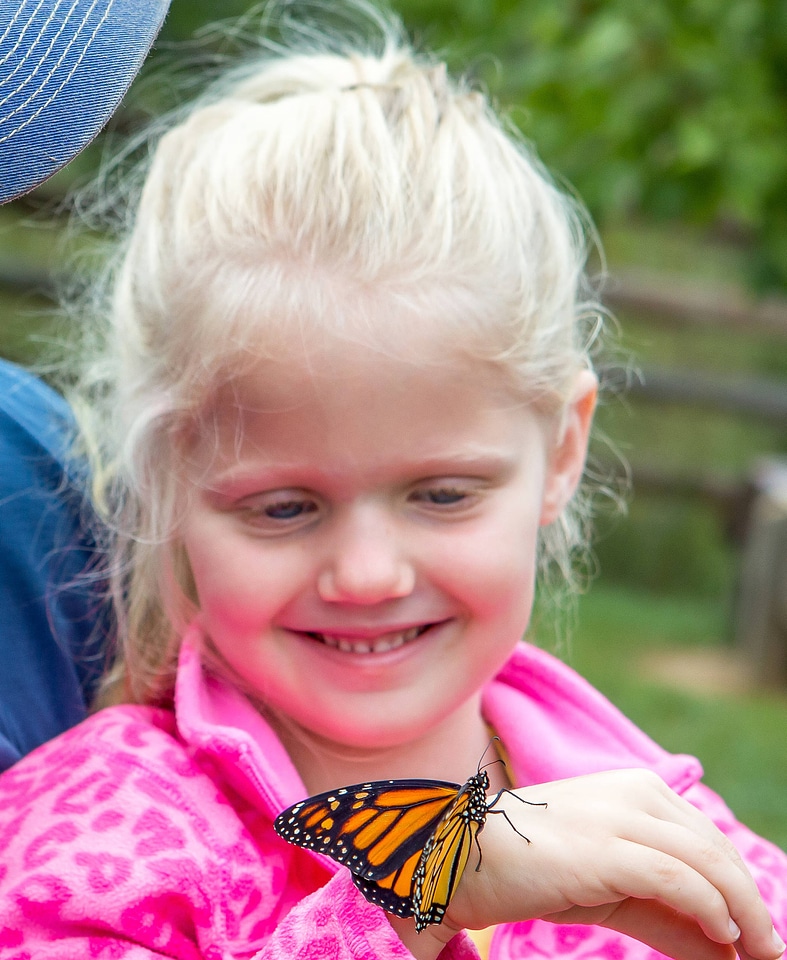 Girl with monarch butterfly on hand