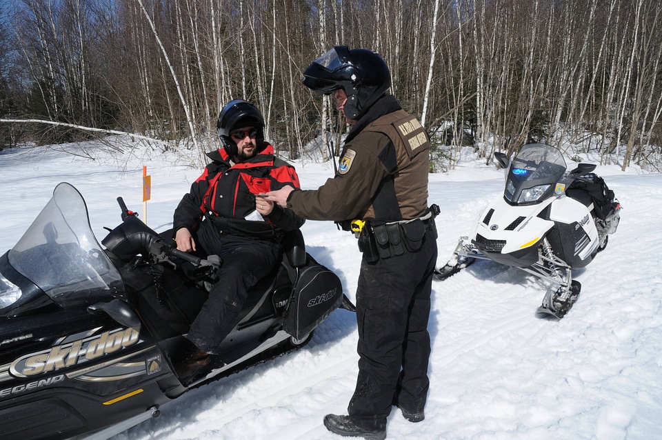 Service Law Enforcement Officer checks a sled driver