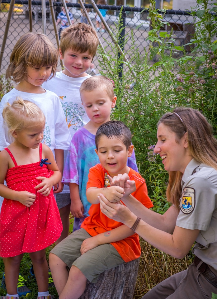 Children with fws employee looking at tagged monarch