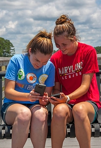 Students sittting on bench sharing cell phone pictures