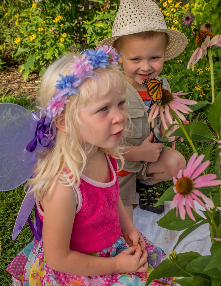 Children look at monarch on flower