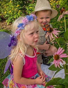 Children look at monarch on flower photo