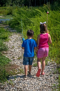 Little boy and girl going fishing, walking along creek-1