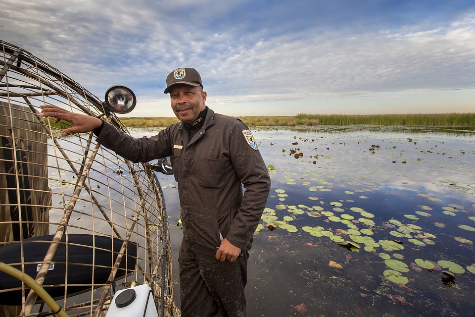 Employee standing beside an airboat at Bayou Sauvage NWR