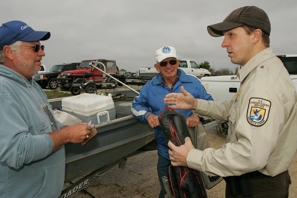 Service employee talking with fishermen at Lacassine National Wildlife Refuge