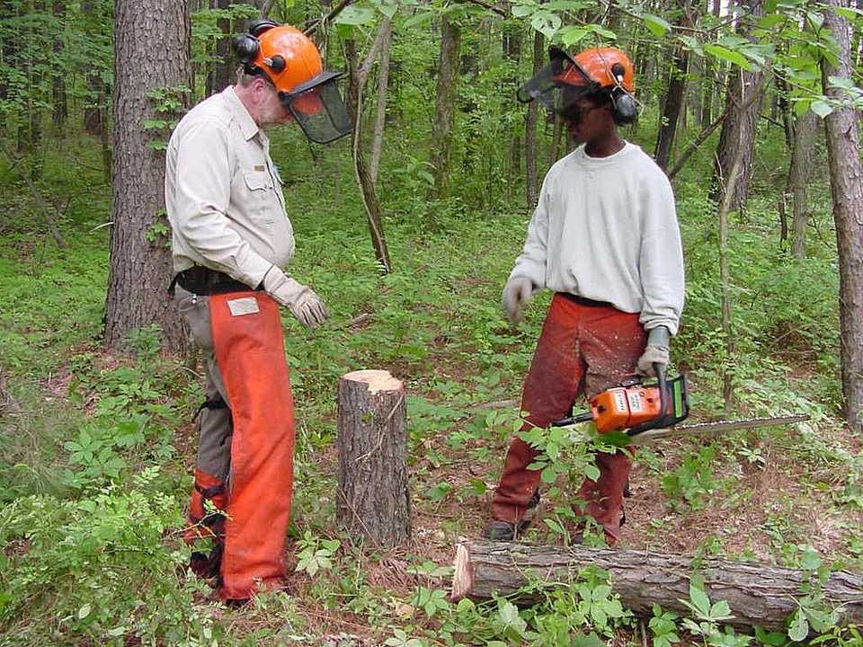 Young man holds chainsaw