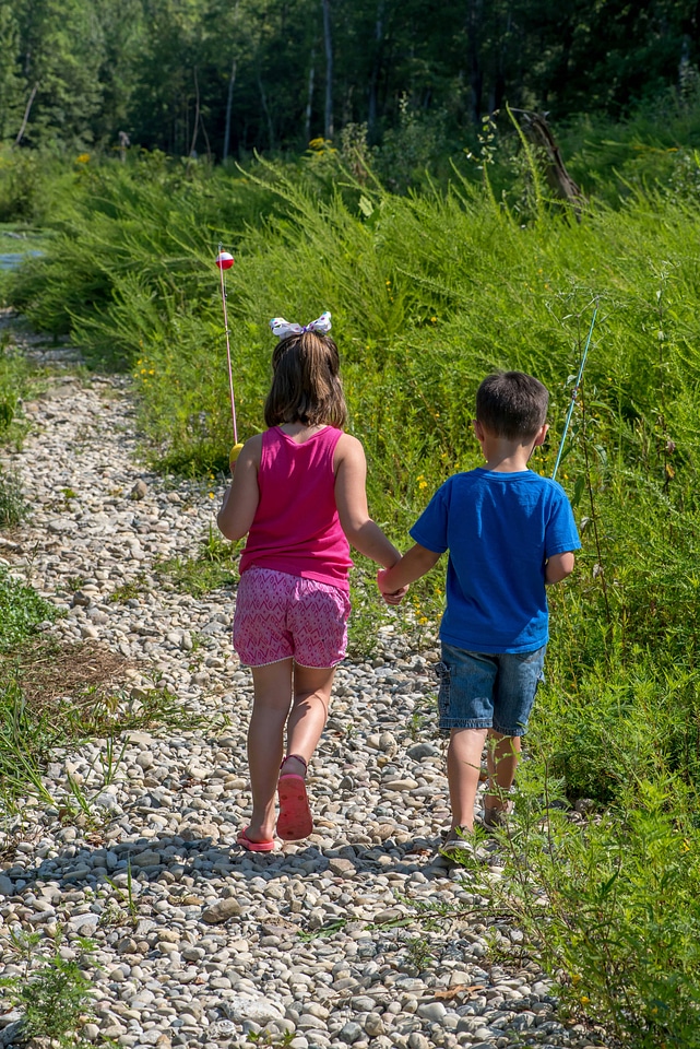 Little boy and girl going fishing, walking along creek-1