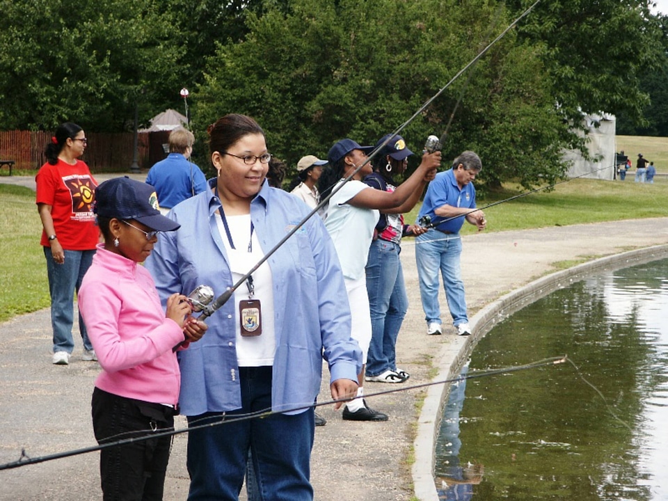 FWS employee helps child to fish