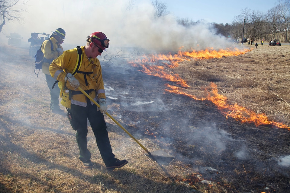 Firefighter using shovel in burn