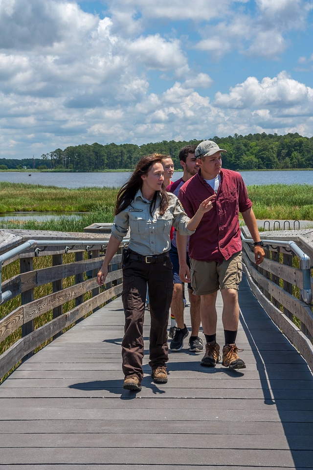 FWS staff leads group of high school students up boardwalk