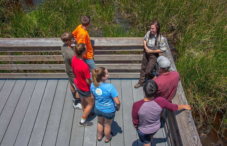 FWS staff talks to group of young students at viewing area