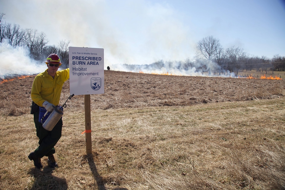Firefighter stands beside sign