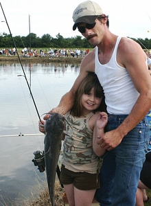 Father and daughter with catfish photo