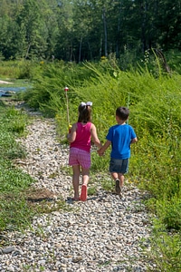Little boy and girl going fishing, walking along creek-3