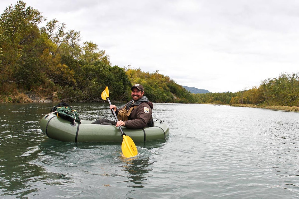 Service employee paddling a river raft