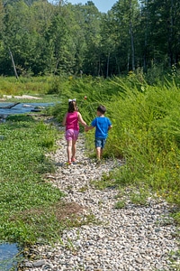 Little boy and girl going fishing, walking along creek-1