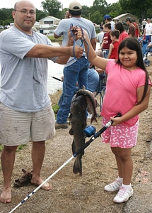 Father and daughter hold fish photo